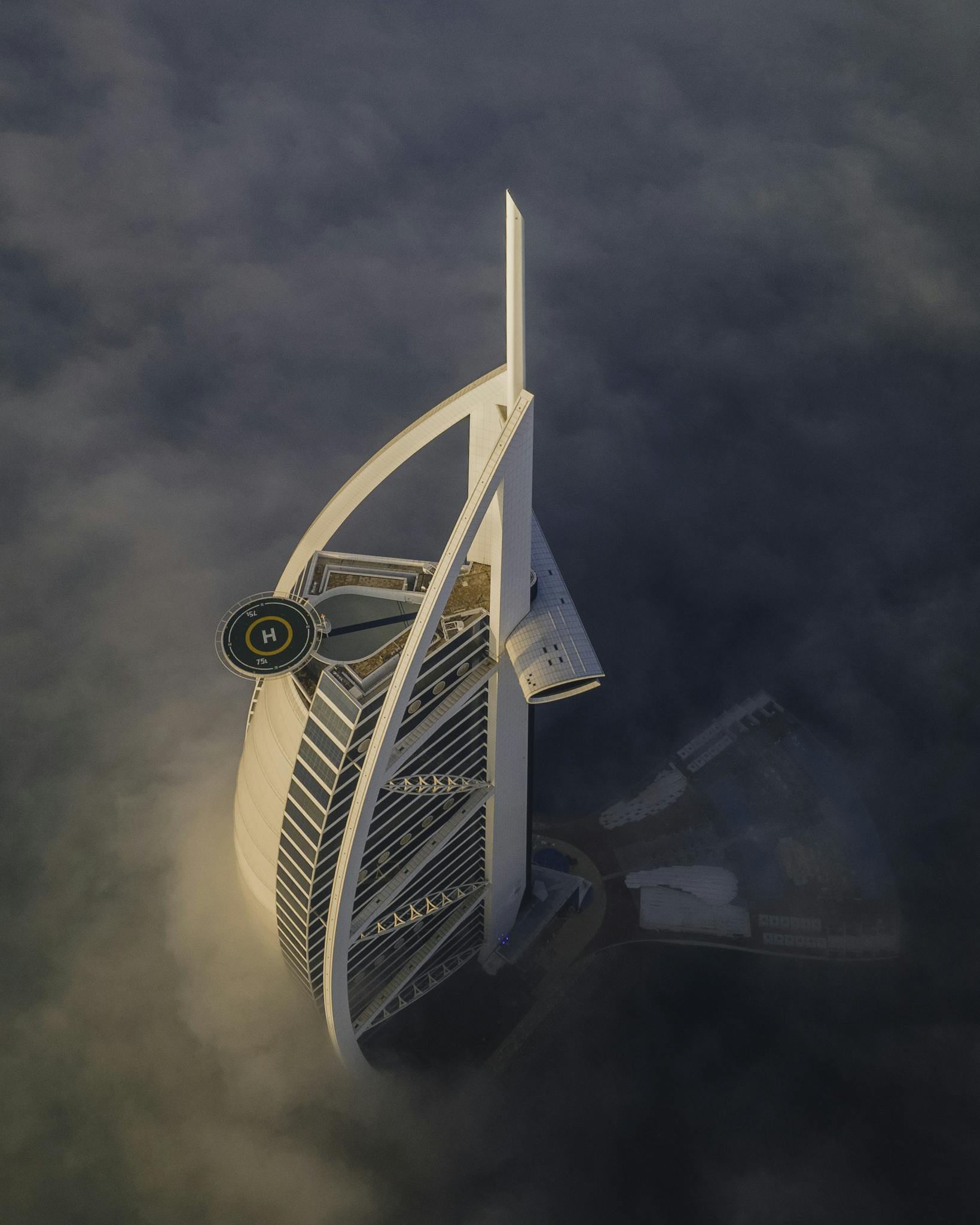 Stunning aerial view of the Burj Al Arab hotel amidst fog in Dubai, UAE.